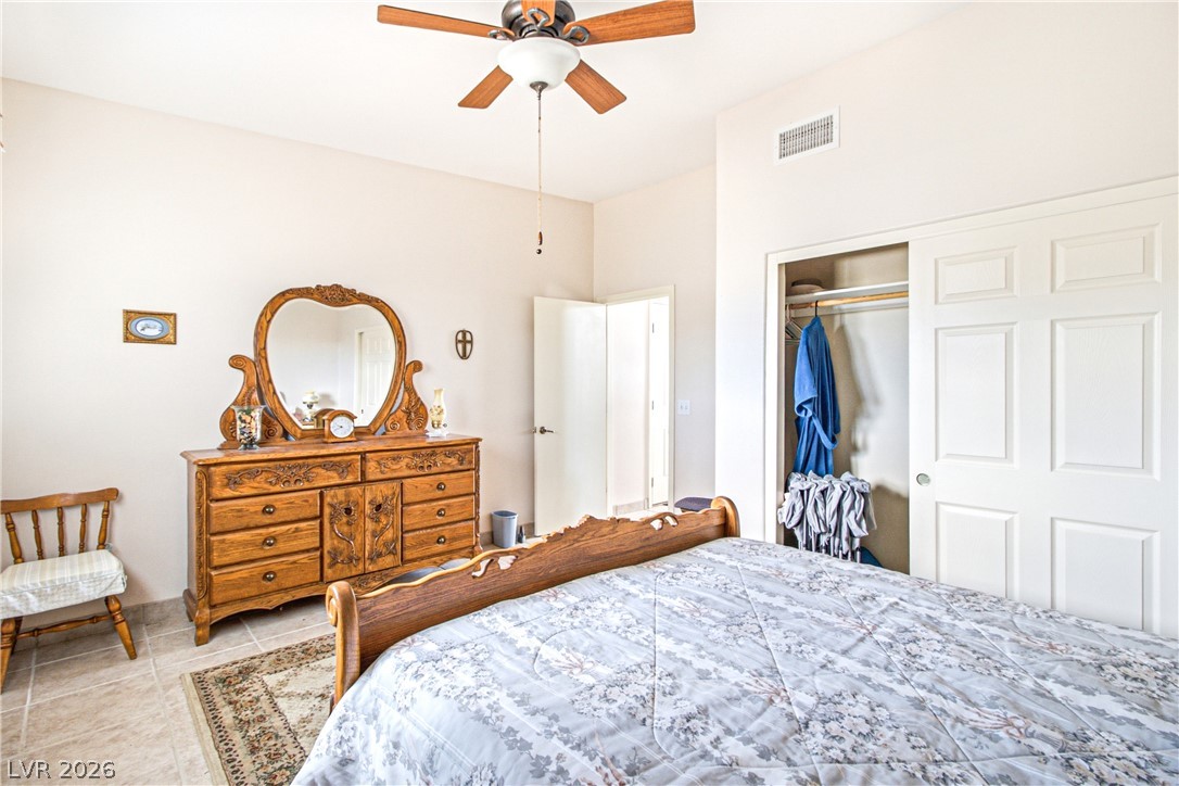 Rocking S Ranch Road Searchlight, NV 89046 - Photo 31 of 47 An inviting bedroom with tile flooring features a ceiling fan, a spacious closet, and a light color palette.