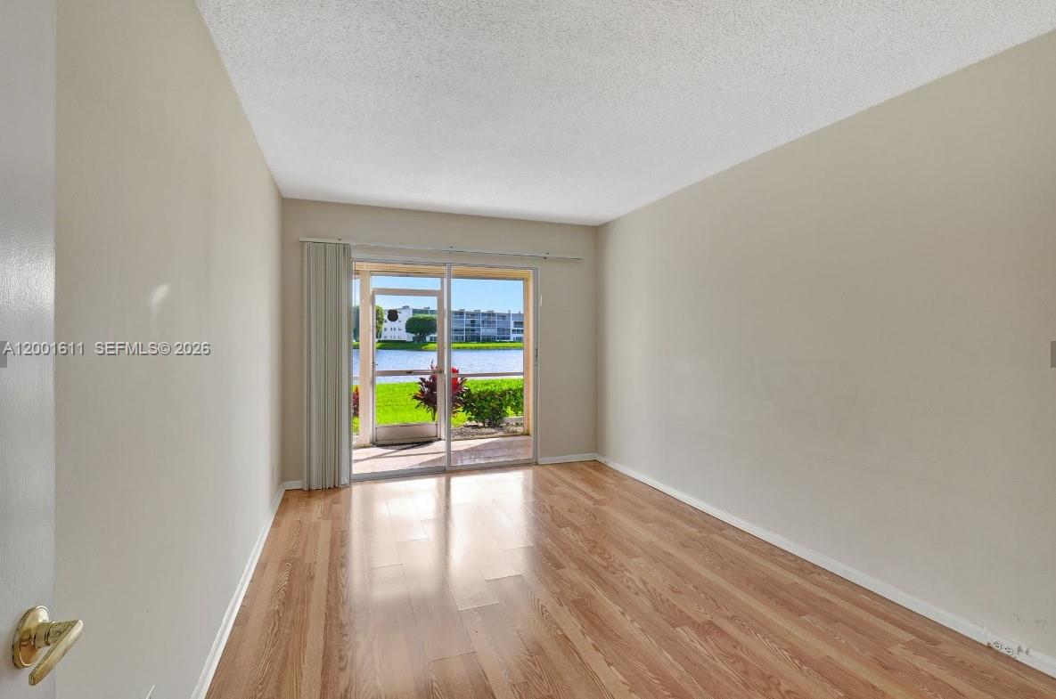 1020 Exeter, Unit 1020 Boca Raton, FL 33434 - Photo 4 of 15 wooden floor in an empty room with a window