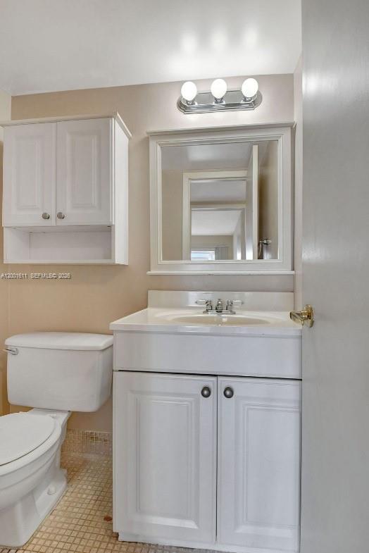 1020 Exeter, Unit 1020 Boca Raton, FL 33434 - Photo 10 of 15 a bathroom with a sink a toilet and a mirror