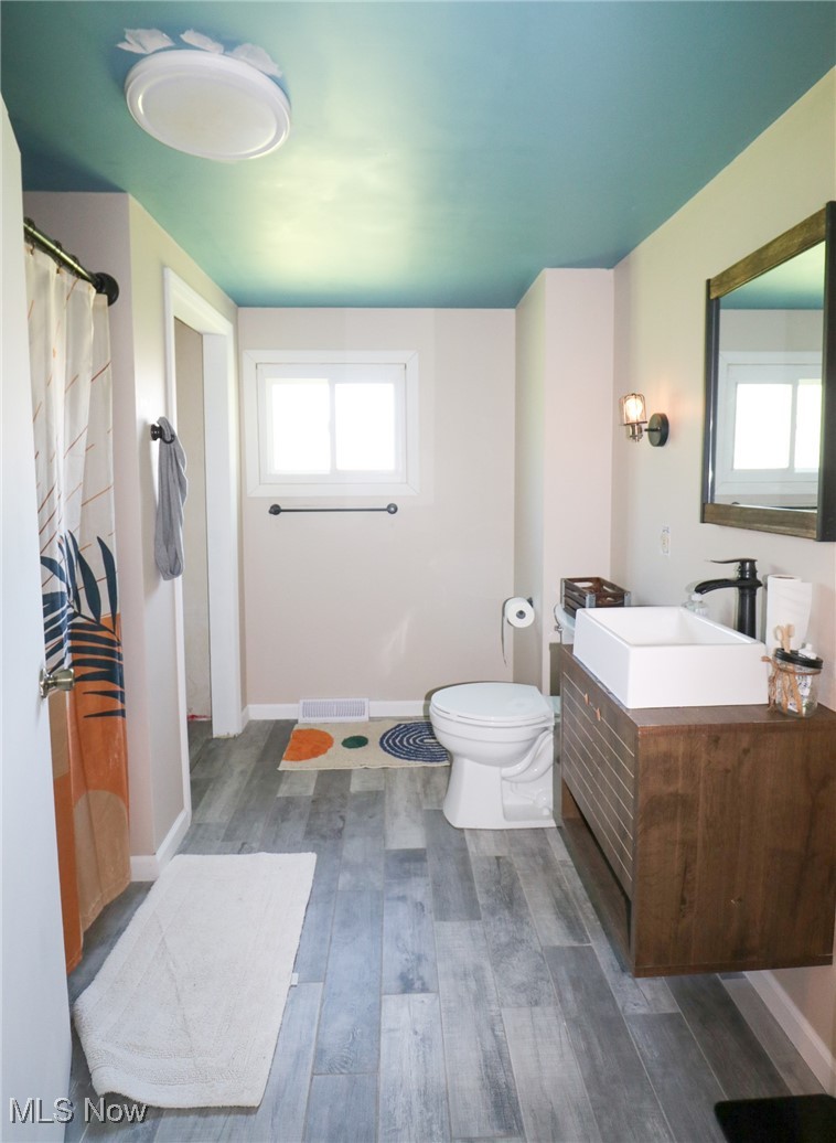 36751 Sugar Ridge Road North Ridgeville, OH 44039 - Photo 9 of 22 Bathroom featuring wood finished floors, toilet, vanity, and baseboards