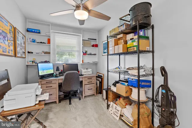 a view of a workspace with furniture and a window