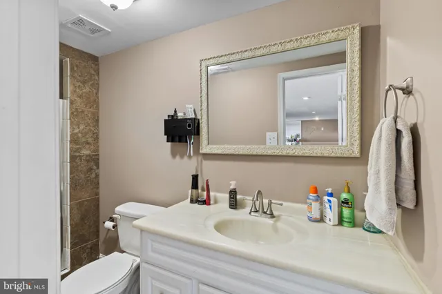 a bathroom with a toilet sink and mirror