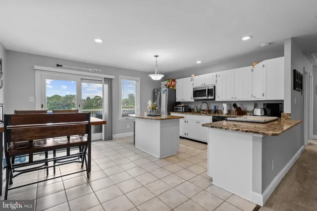 a kitchen with stainless steel appliances kitchen island granite countertop a sink and cabinets