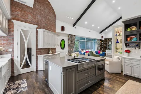 a kitchen that has a stove and a wooden floor