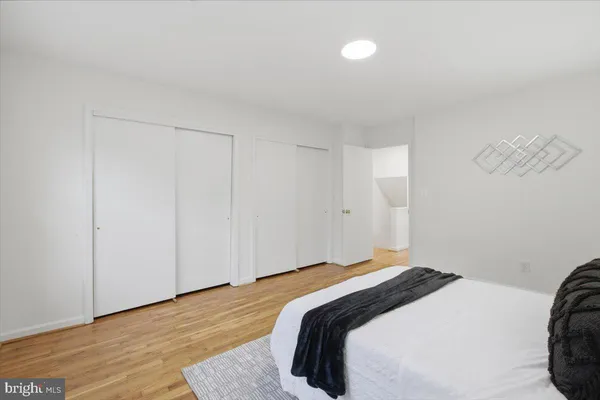 a bedroom with a bed and a lamp on the dresser