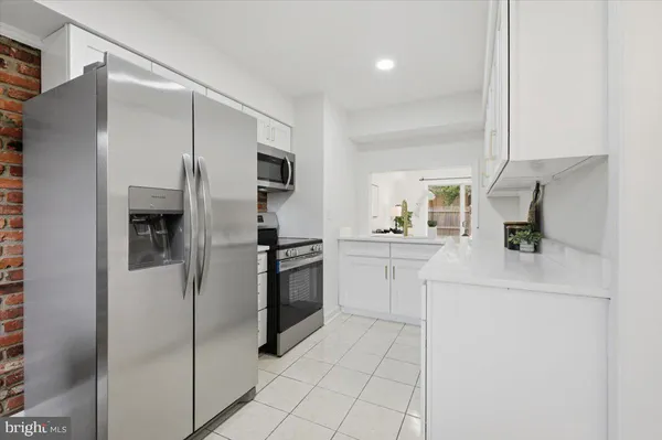 a kitchen with a refrigerator sink and cabinets