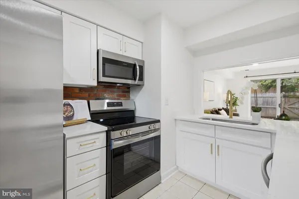 a kitchen with white cabinets stainless steel appliances and a sink