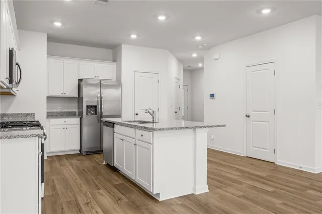 a kitchen with stainless steel appliances granite countertop a stove a sink and a refrigerator