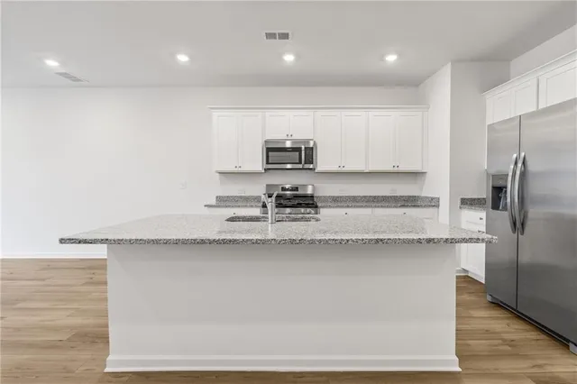 a kitchen with stainless steel appliances granite countertop a sink stove and cabinets