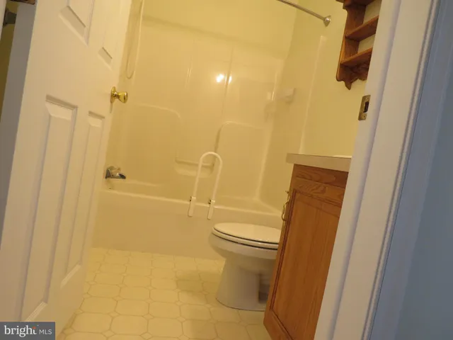 a bathroom with a granite countertop toilet and shower
