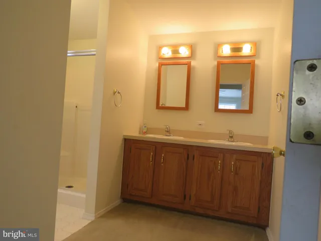 a spacious bathroom with a double vanity sink and a mirror