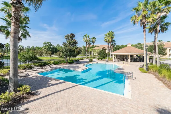 a view of a patio with a table and chairs under an umbrella