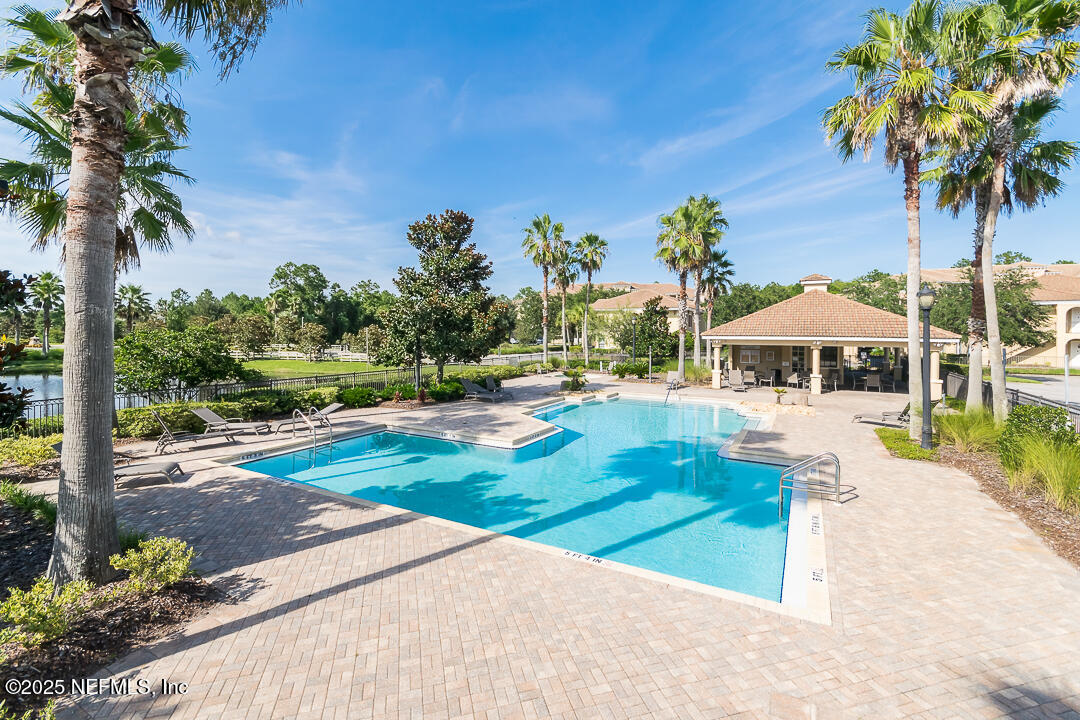 415 La Travesia Flora, Unit 102 St. Augustine, FL 32095 - Photo 11 of 11 a view of a patio with a table and chairs under an umbrella