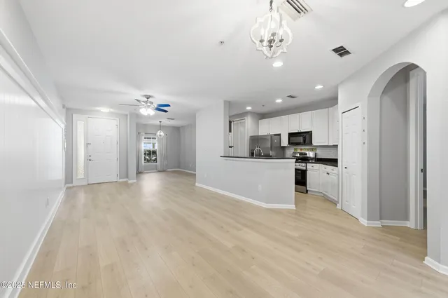 a view of kitchen with refrigerator sink and cabinets
