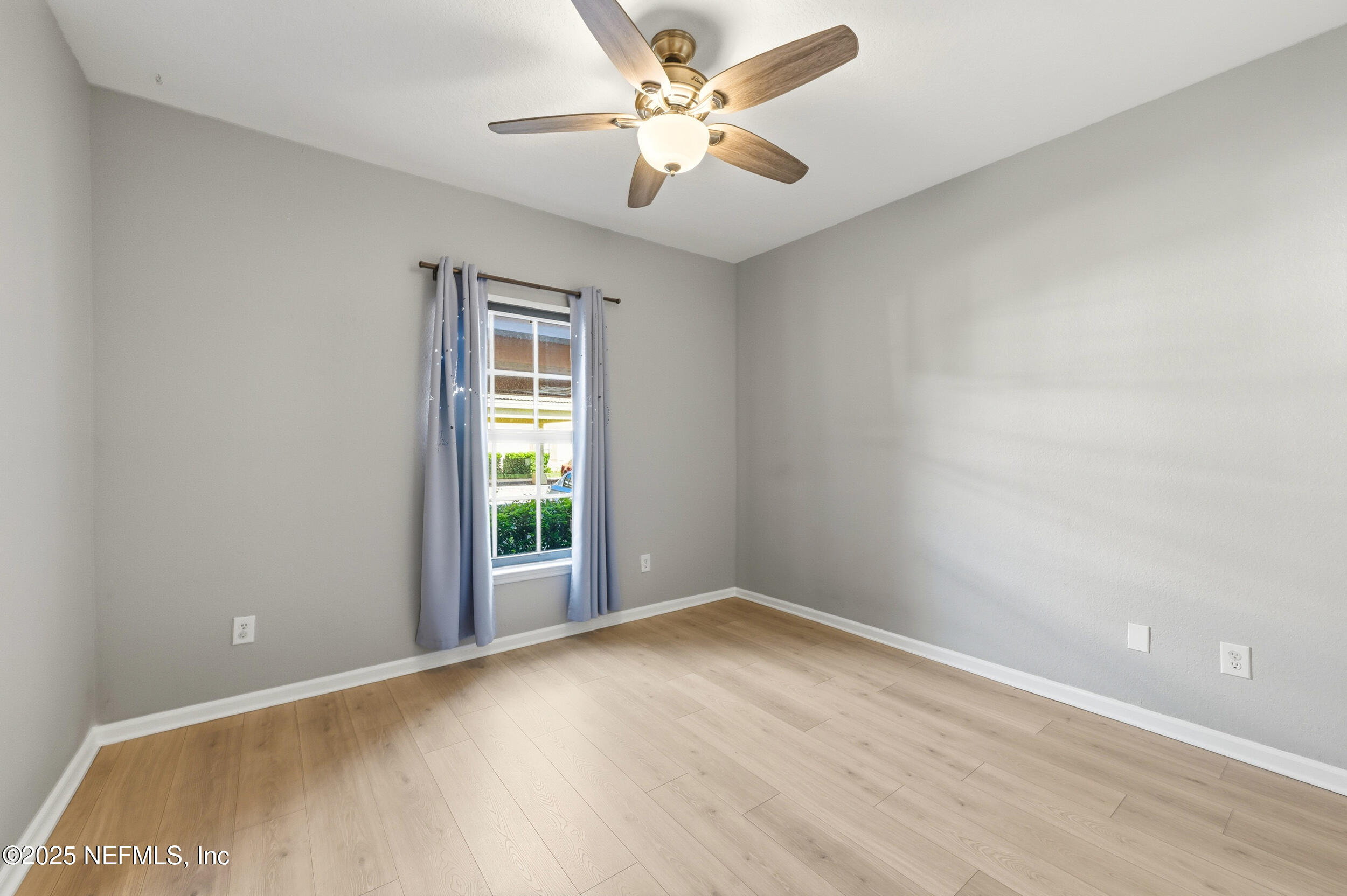 415 La Travesia Flora, Unit 102 St. Augustine, FL 32095 - Photo 7 of 11 wooden floor in an empty room with a window