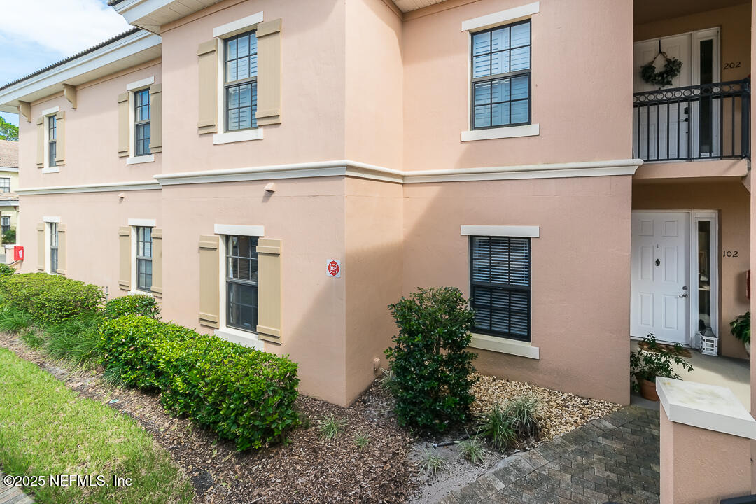 415 La Travesia Flora, Unit 102 St. Augustine, FL 32095 - Photo 10 of 11 front view of house with large windows and plants