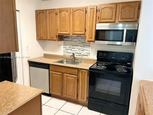 a kitchen with stainless steel appliances granite countertop a stove microwave and sink