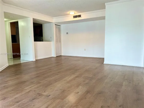 a view of an empty room with wooden floor