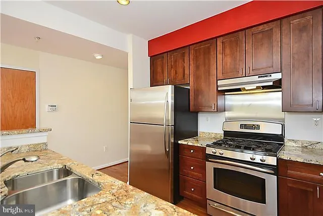 a kitchen with a stove a refrigerator and a sink
