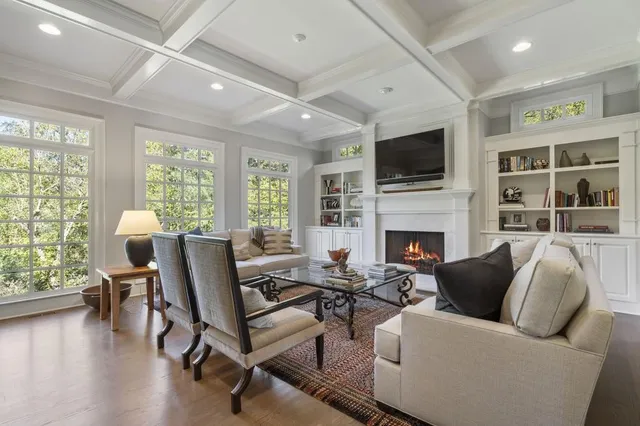 a living room with furniture and a to ceiling window