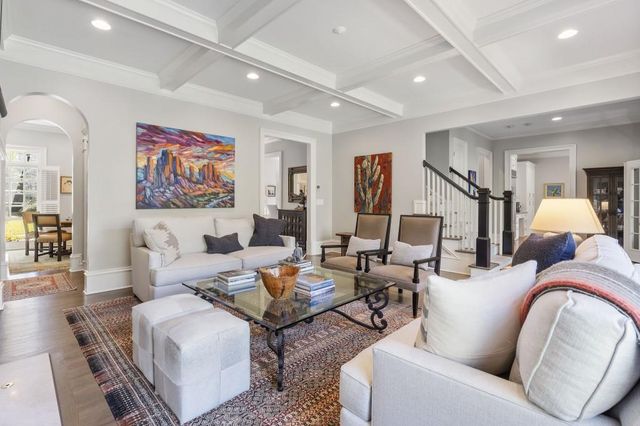 a living room with furniture a large window and chandelier