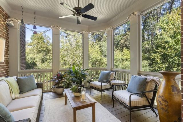 a view of staircase with lots of frames on wall and a large window