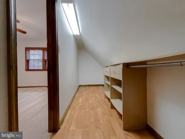 a view of walk in closet with wooden floor