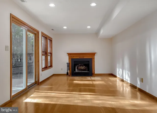 a view of an empty room with a fireplace and a window