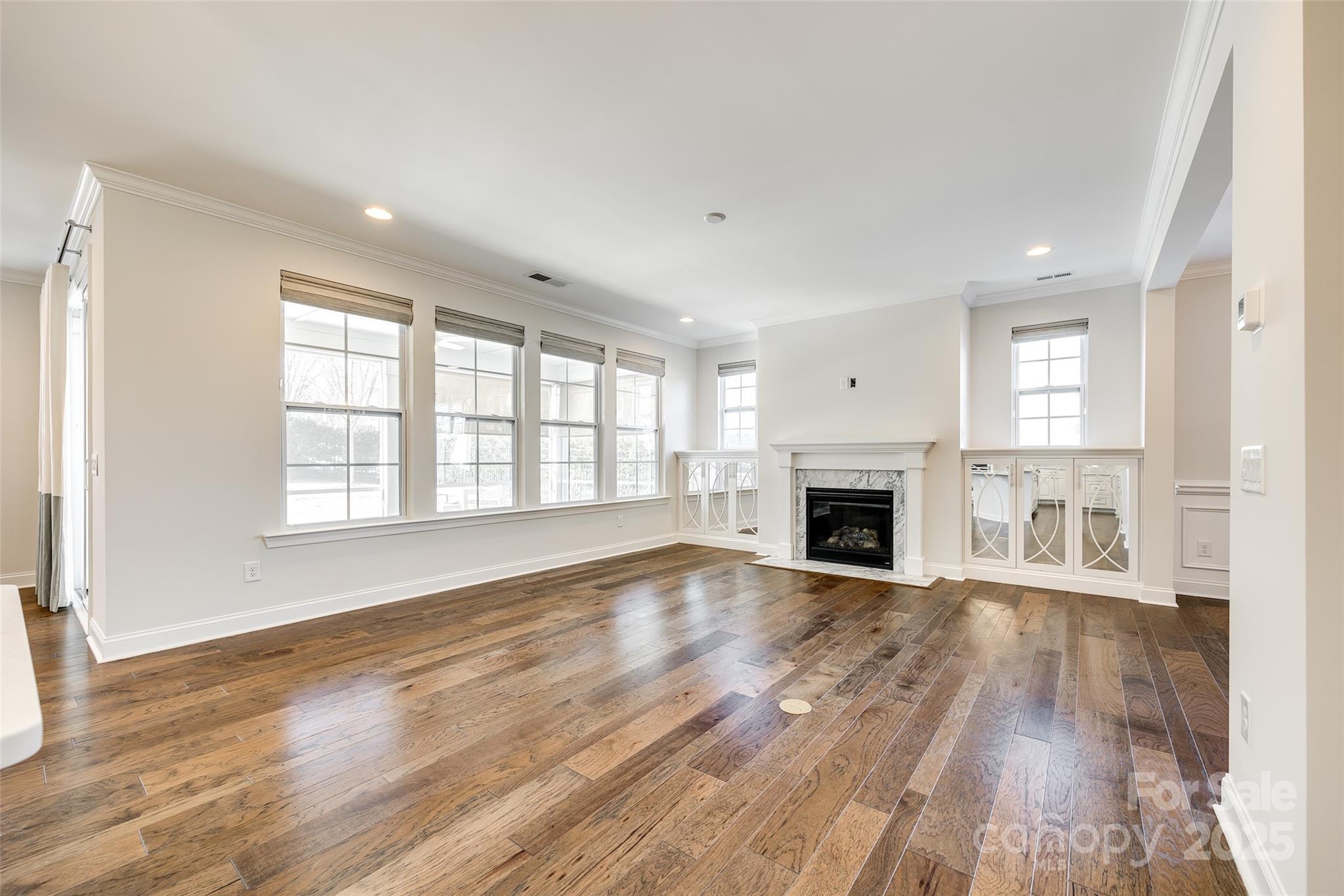 1056 Emory Lane Fort Mill, SC 29708 - Photo 8 of 48 an empty room with wooden floor fireplace and windows
