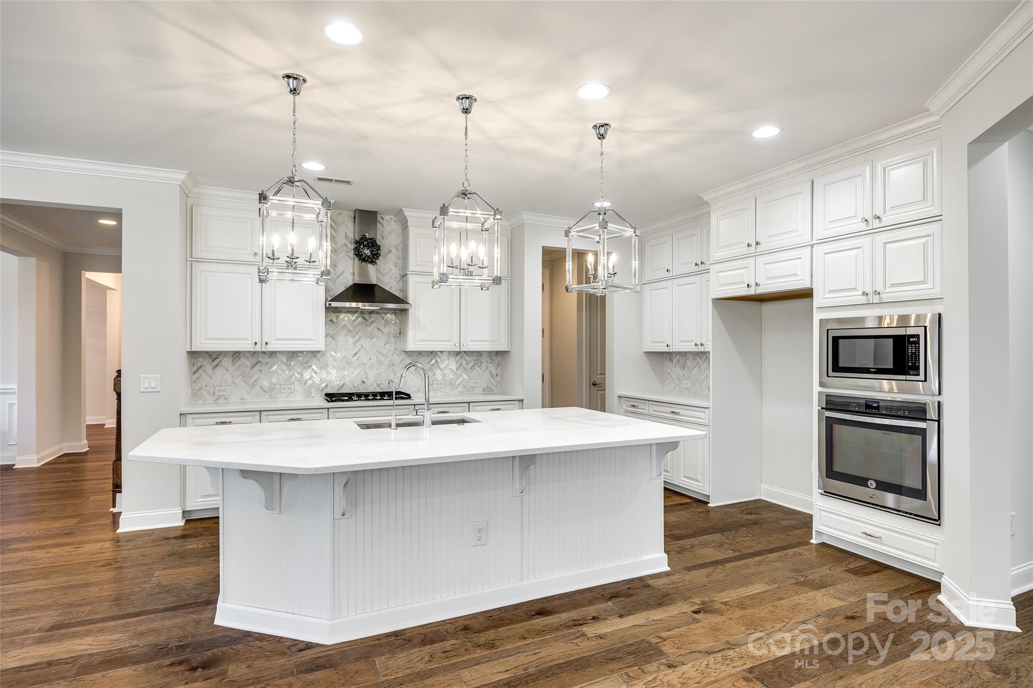 1056 Emory Lane Fort Mill, SC 29708 - Photo 10 of 48 a large kitchen with stainless steel appliances kitchen island granite countertop a stove a refrigerator a sink and a oven with wooden floor