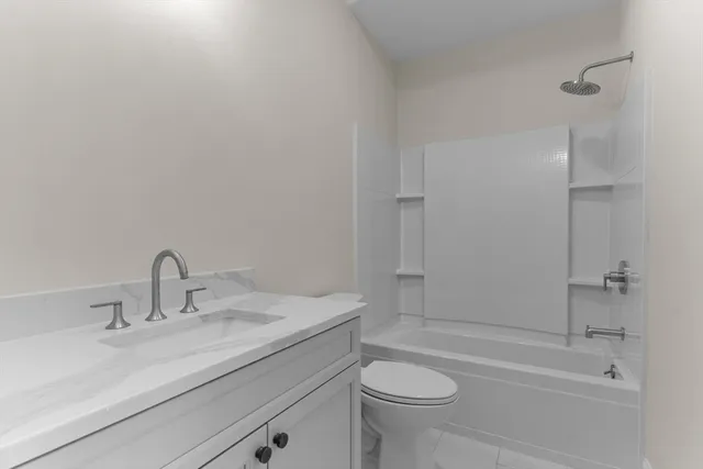a bathroom with a granite countertop sink a toilet and shower