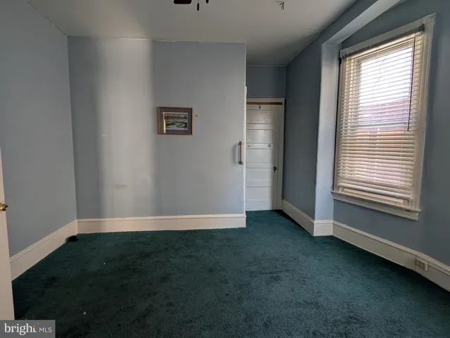 an empty room with windows and cabinet