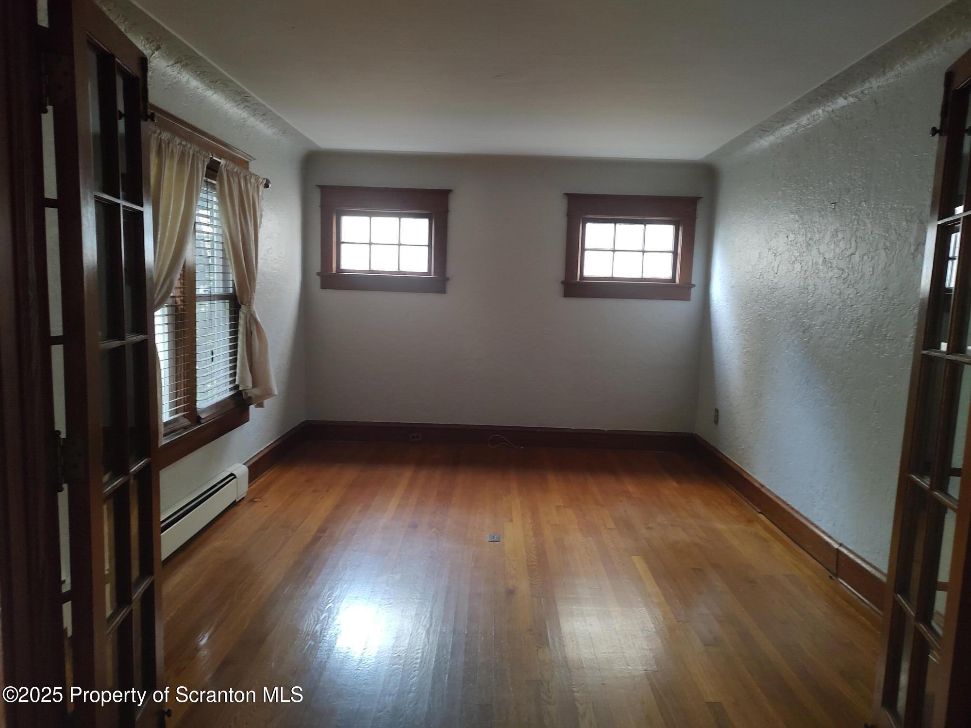 215 West Grove Street Clarks Summit, PA 18411 - Photo 10 of 26 an empty room with wooden floor and windows