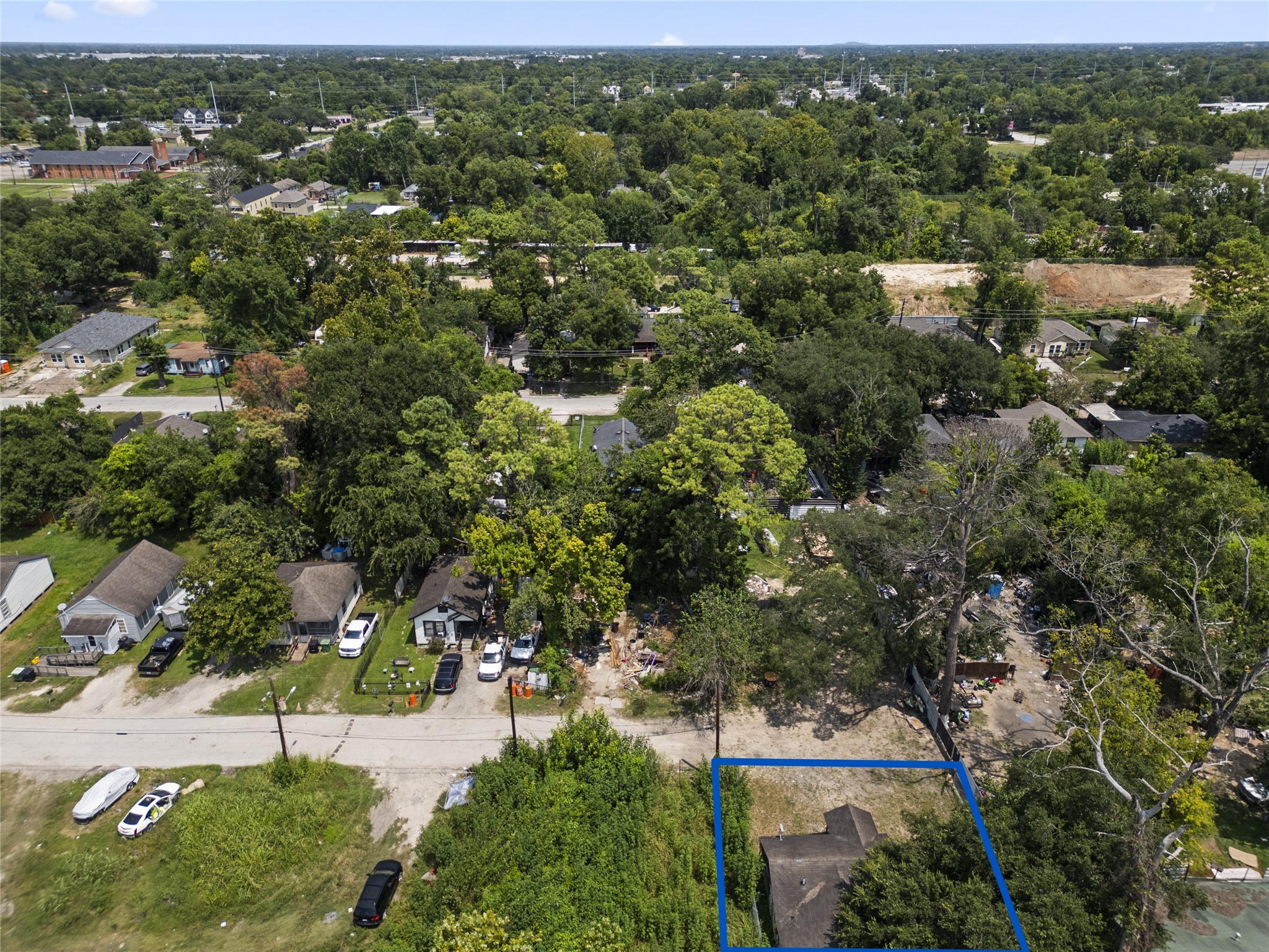 an aerial view of residential houses with outdoor space and trees
