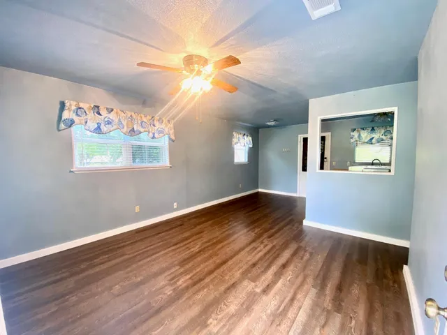 a view of an empty room window and wooden floor