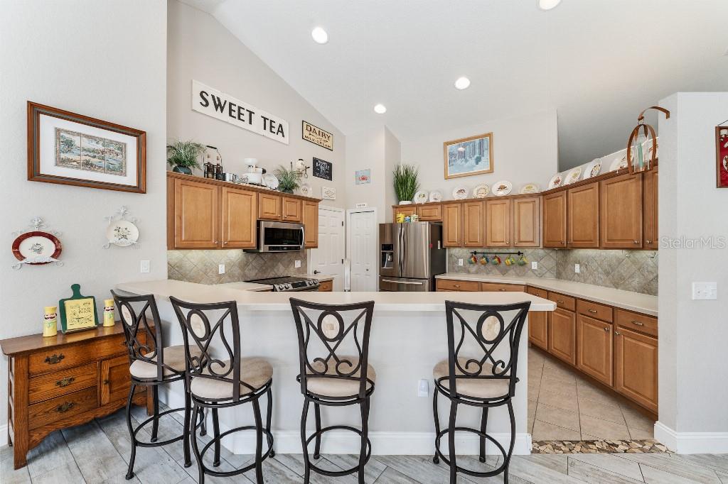 19115 Southwest 98th Loop Dunnellon, FL 34432 - Photo 16 of 36 a kitchen with stainless steel appliances kitchen island granite countertop a table chairs in it and wooden floors