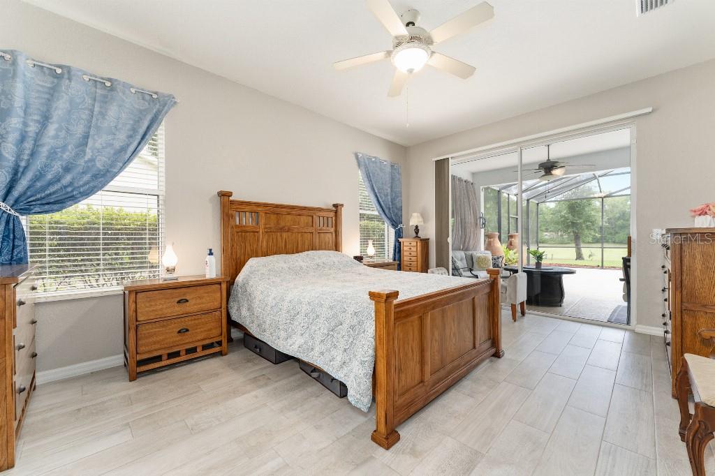 19115 Southwest 98th Loop Dunnellon, FL 34432 - Photo 17 of 36 a spacious bedroom with a bed and a chandelier