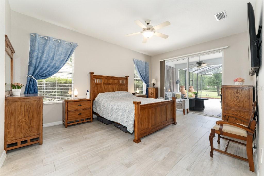 19115 Southwest 98th Loop Dunnellon, FL 34432 - Photo 18 of 36 a bedroom with a bed and large windows