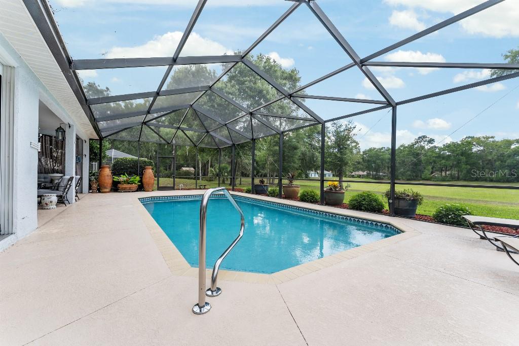 19115 Southwest 98th Loop Dunnellon, FL 34432 - Photo 24 of 36 a view of a swimming pool with a patio and a yard