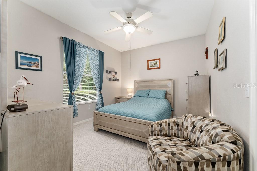 19115 Southwest 98th Loop Dunnellon, FL 34432 - Photo 29 of 36 a bedroom with a bed and a chandelier