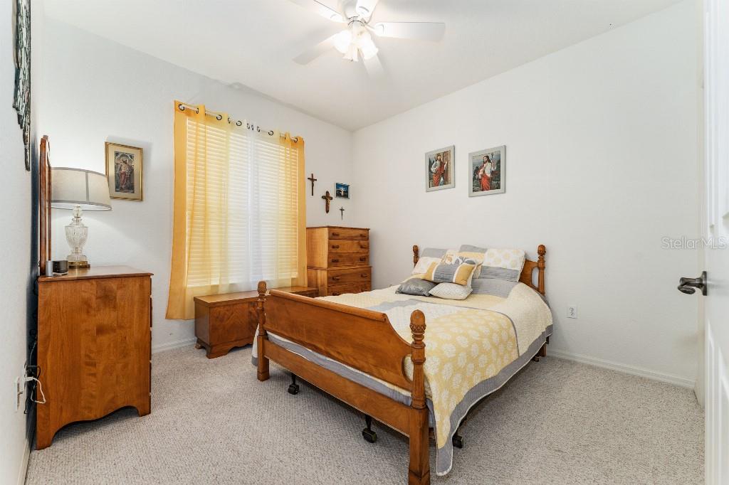 19115 Southwest 98th Loop Dunnellon, FL 34432 - Photo 30 of 36 a bedroom with a bed and a chandelier