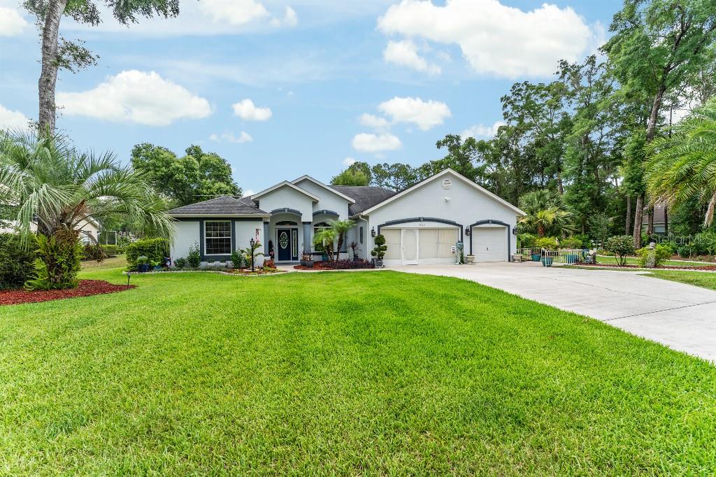 19115 Southwest 98th Loop Dunnellon, FL 34432 - Photo 3 of 36 a view of house with garden and tall trees
