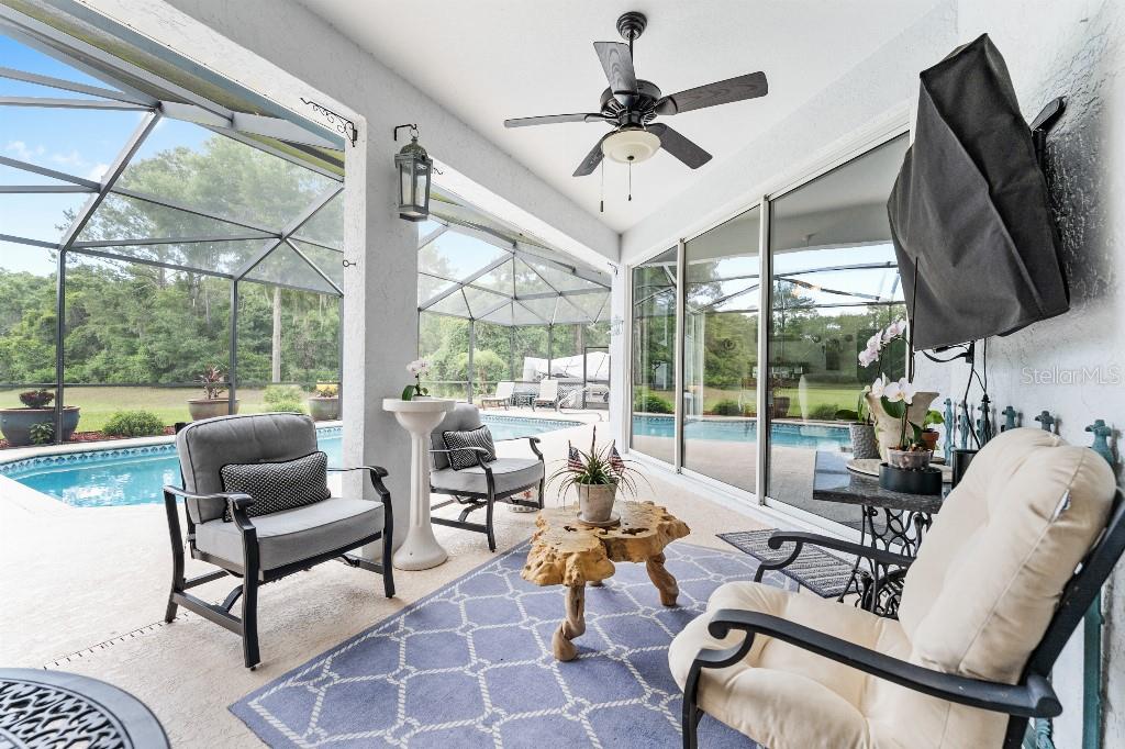 19115 Southwest 98th Loop Dunnellon, FL 34432 - Photo 32 of 36 a living room with patio fireplace furniture and a large window