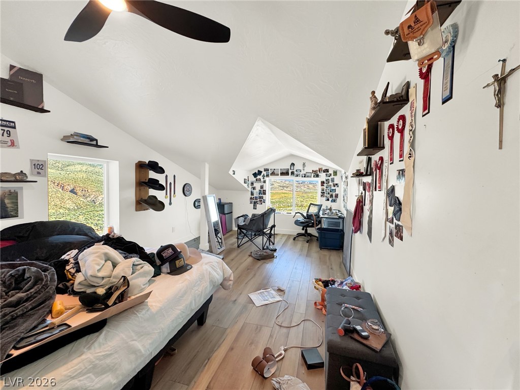 9393 North 93rd Highway Caliente, NV 89008 - Photo 11 of 41 Sloped ceilings and an inviting window frame picturesque views, defining this charming bedroom's character.