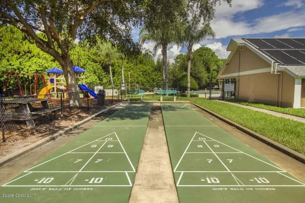 a view of a tennis ground with large trees