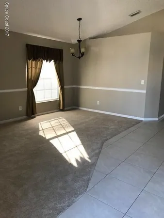 en empty room with windows and fan