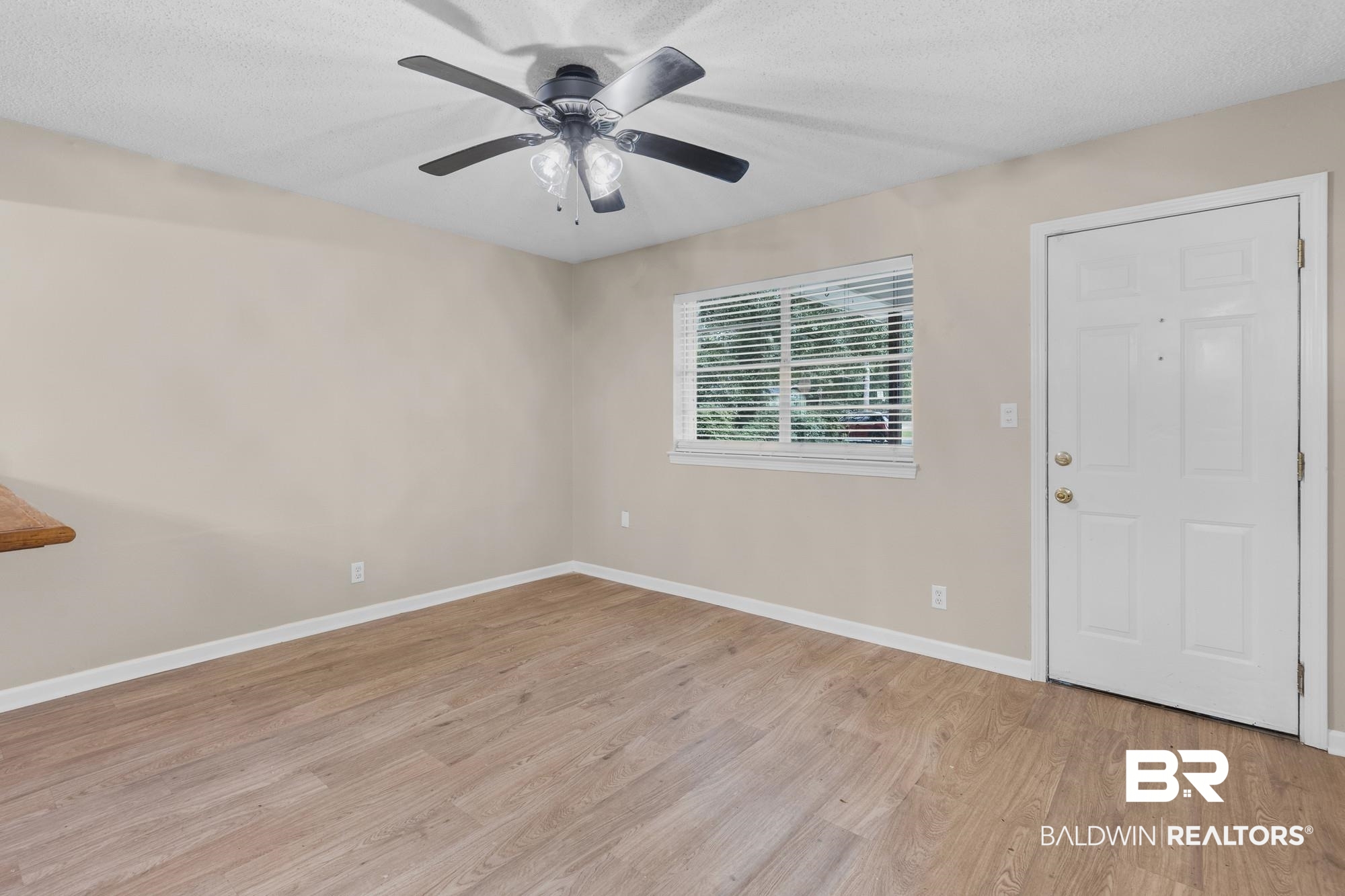1560 Military Road Mount Vernon, AL 36560 - Photo 10 of 26 Open-concept living area with wood-finish flooring, a contemporary ceiling fan, and a paneled entry door