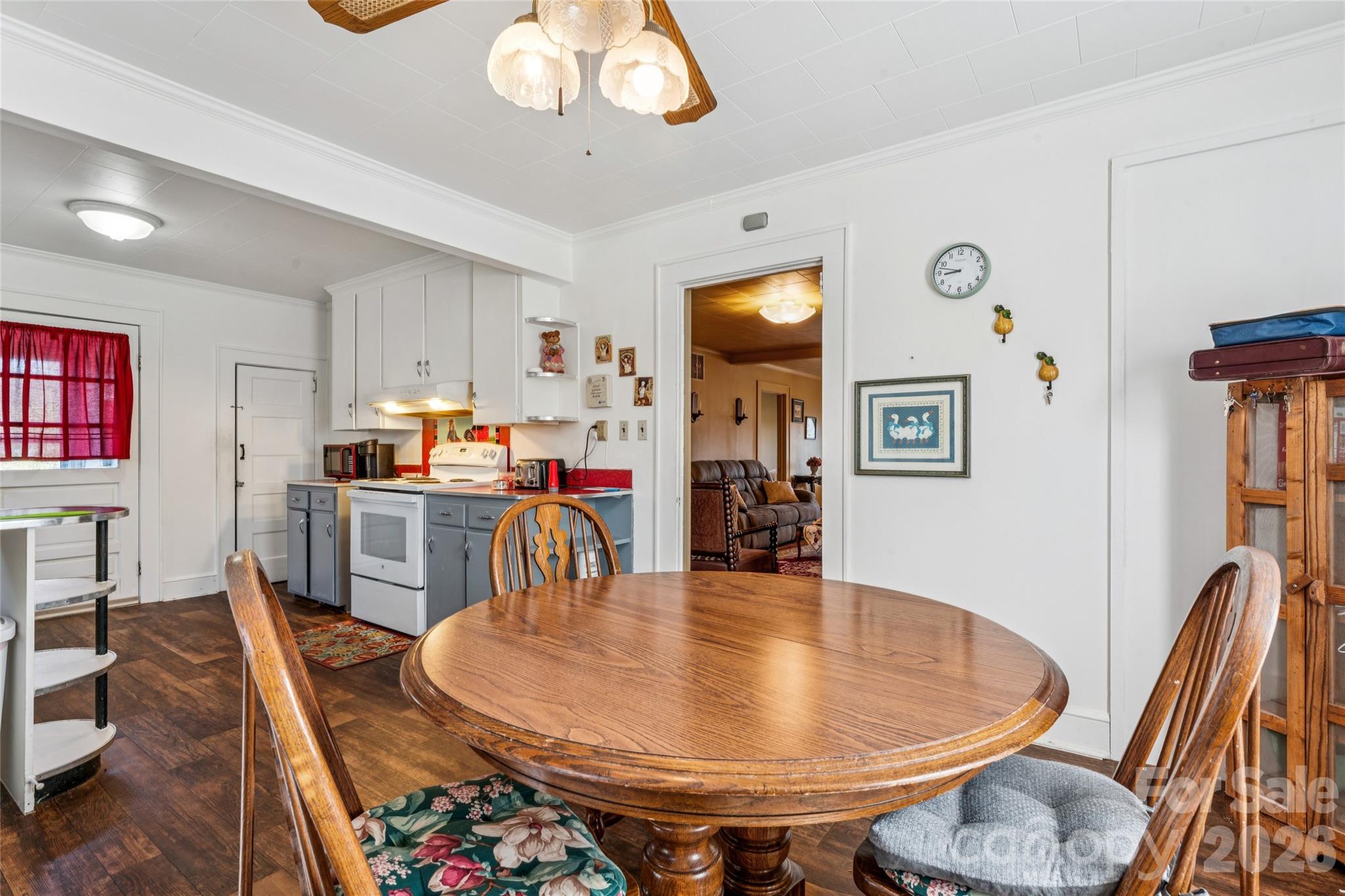 7910 Highway 90 Stony Point, NC 28678 - Photo 12 of 28 a dining room with wooden floor a chandelier a wooden table and chairs