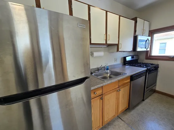 a kitchen with stainless steel appliances granite countertop a refrigerator and a sink