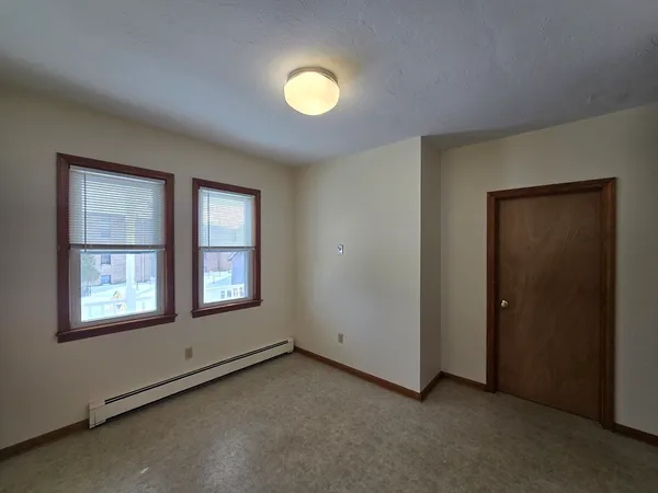 an empty room with windows and closet